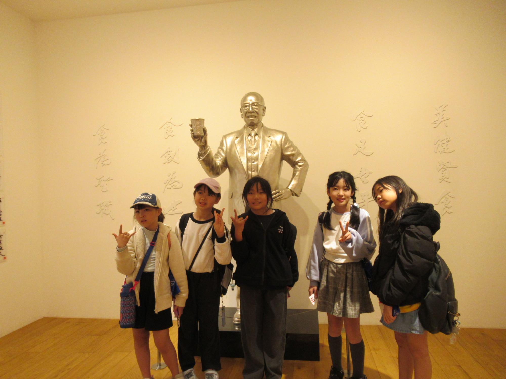 校外活動事業安藤百福像と記念撮影