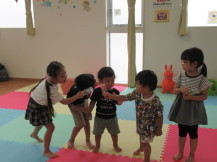 手作りの楽器を歌に合わせて振っている5人の子供たちの写真