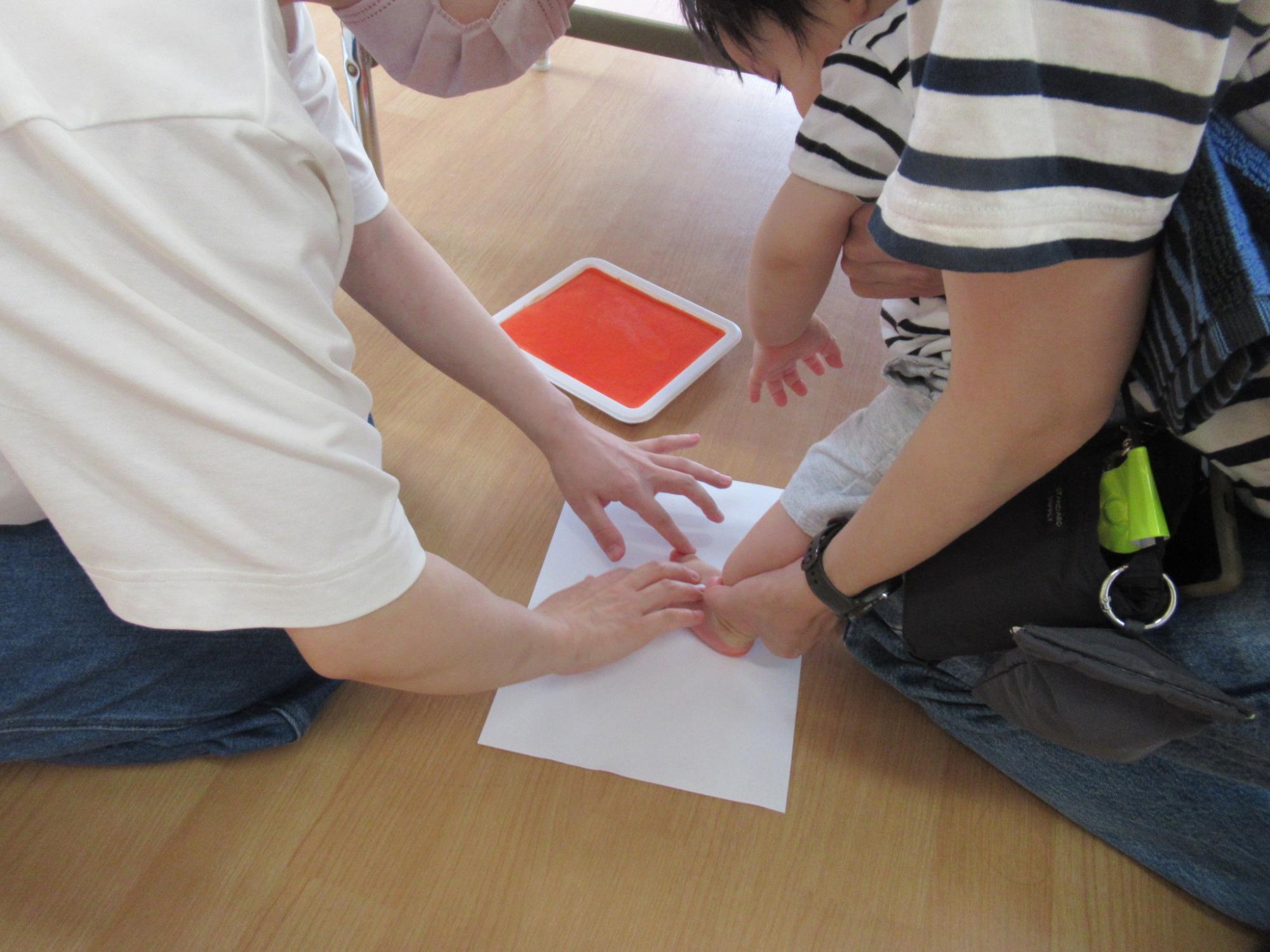 いちごぐみ足形スタンプを押している様子