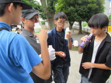 作業が終わってジュースを飲みながら話をする4人の男子中学生の写真