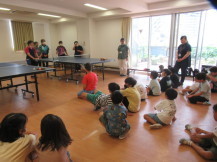 講師のお話を座って聞いている参加者の子供たちを撮影している写真