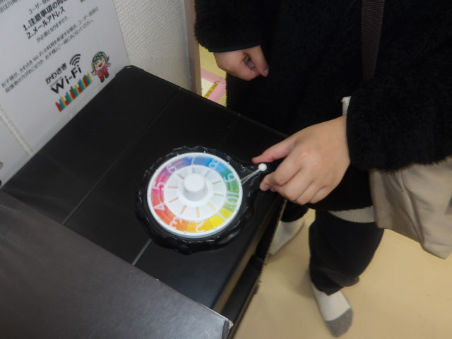 人生ゲームのルーレットをまわしている小学生の写真