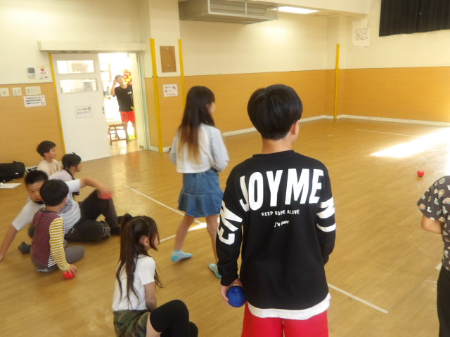 決められた線に立ちボールを投げる小学生の写真