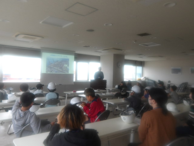 川崎港の説明をする川崎港職員と説明を聞く子供達の写真