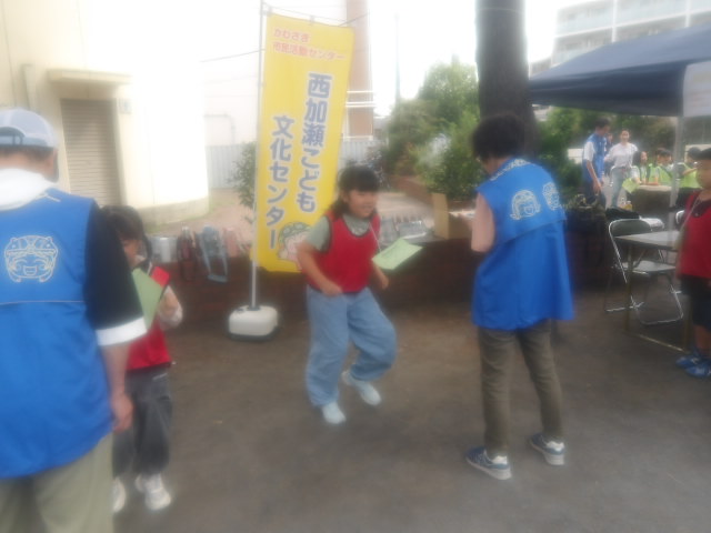 その場で走り、万歩計の回数の記録を競うゲームに挑戦する子供達の写真