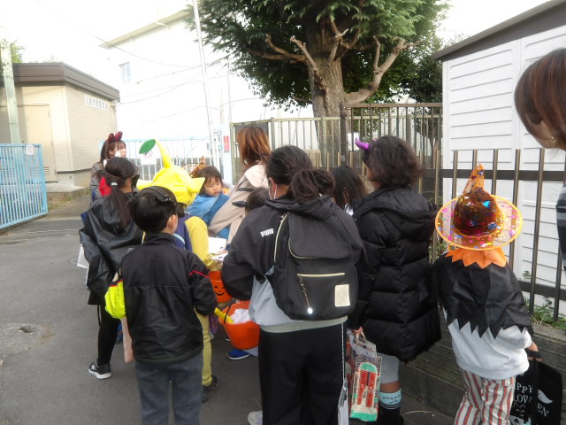 街灯が少なく細い道の説明をするこども文化センター職員と説明を聞く子供達の写真