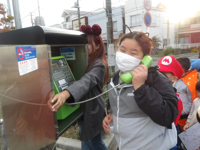 公衆電話をかける子供の写真