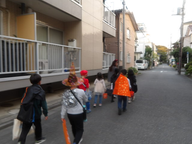 こども110番を探しながらこども文化センターに戻る子供達とこども文化センター職員の写真