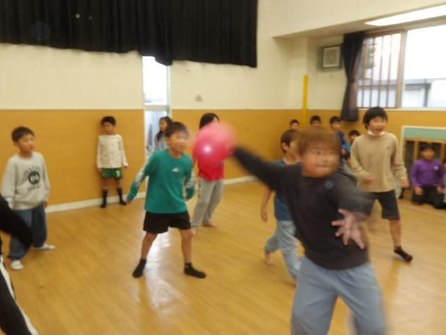 相手チームにボールを投げる男子小学生の写真