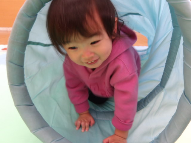 幼児用のトンネルに入り、楽しんでいる幼児の写真