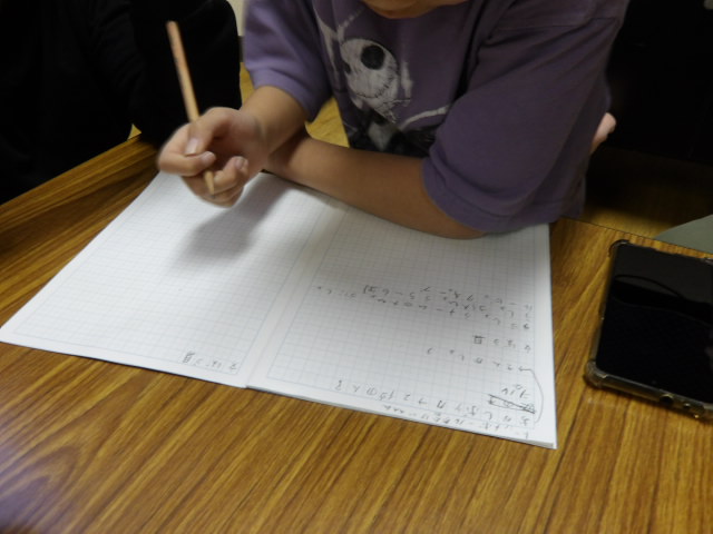 1月21日に開催するドッジボール大会の景品を、ノートに書いていく小学生男子の写真