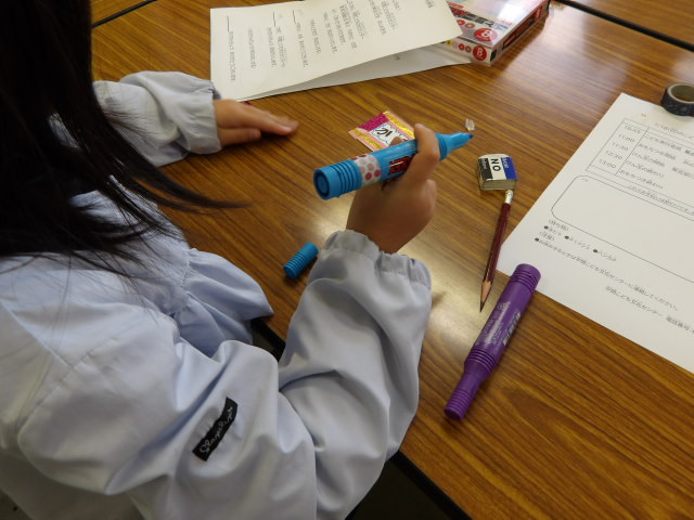水色の水性ペンで名札に色を付ける子ども実行委員の写真