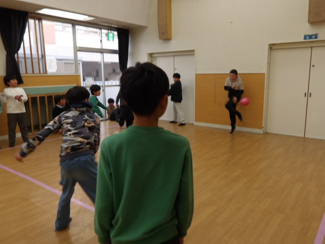 相手チームにボールを投げる小学生と投げられたボールを避ける小学生の写真