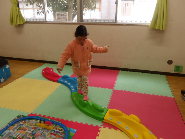 バランスブロックサークルという凸凹した知育運動玩具の上を歩く幼児の写真