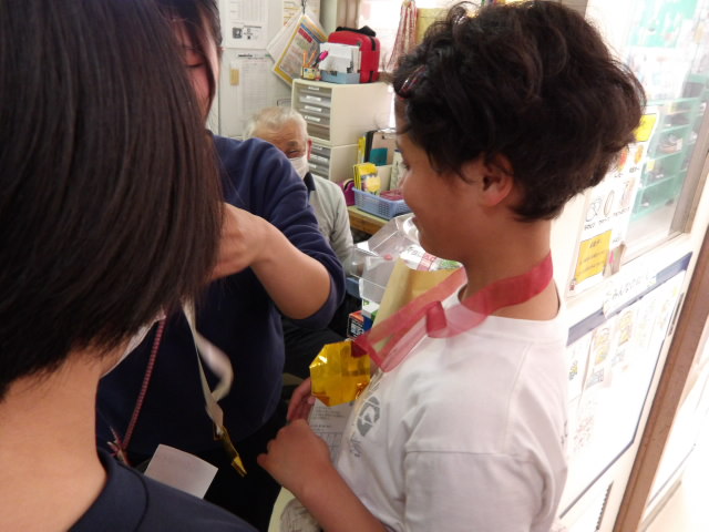 職員から全てメダルを首にかけてもらう小学生の写真
