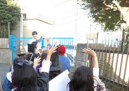 街灯が少なく細い道の説明をするこども文化センター職員と説明を聞く子供達の写真