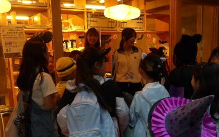 平間商店街にある駄可笑屋敷の店員からお菓子をもらう子供達の写真