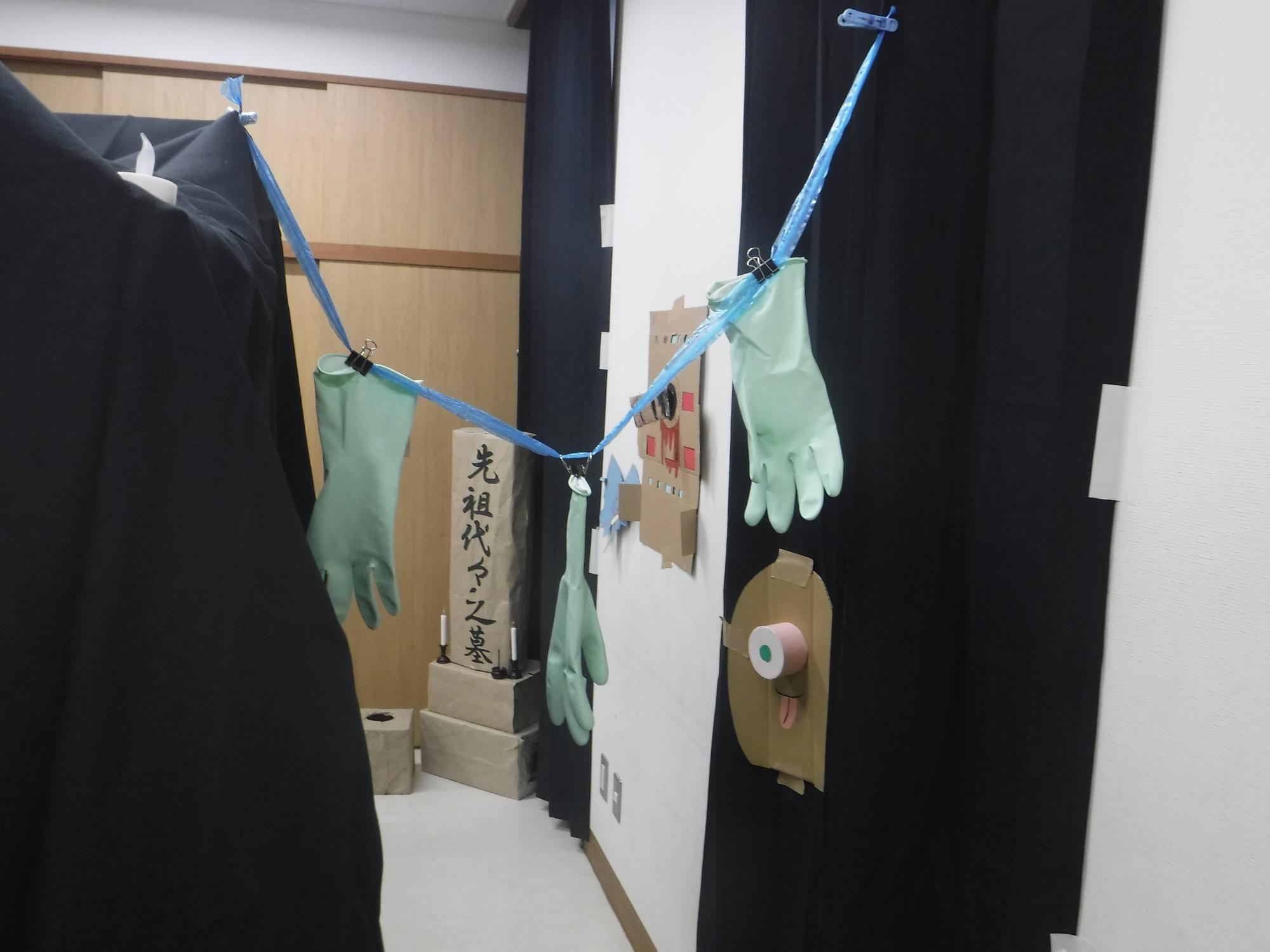 お化け屋敷のお墓と手袋がぶらさがっている写真