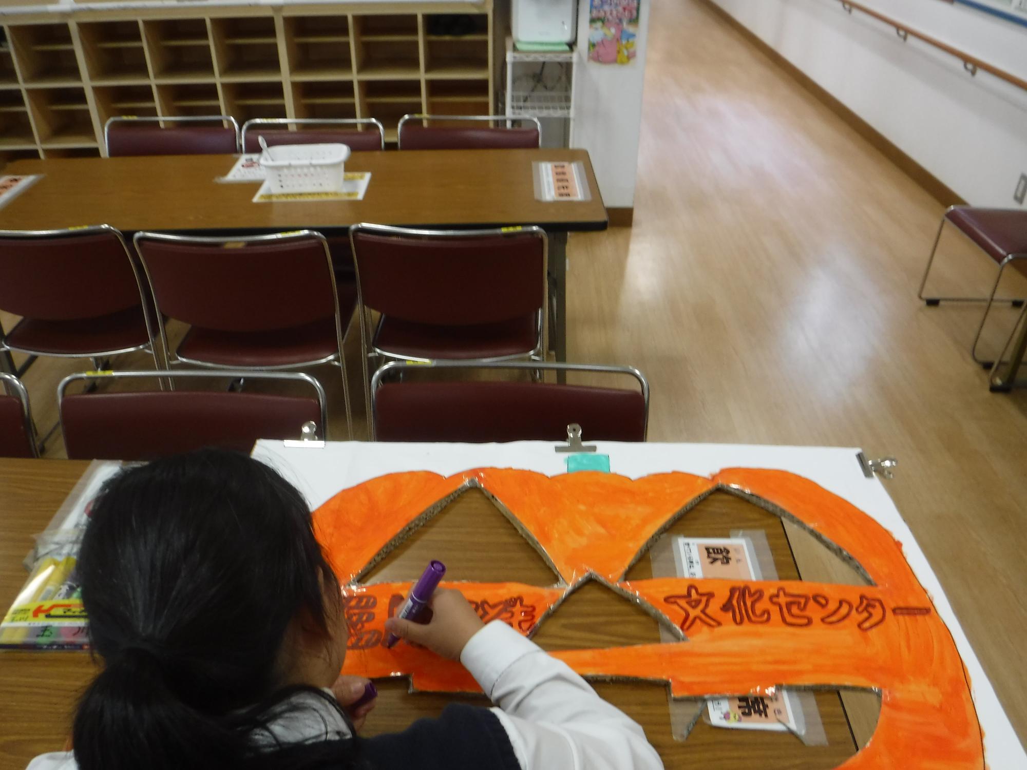 カボチャのお化けの用紙に文字を描いている写真