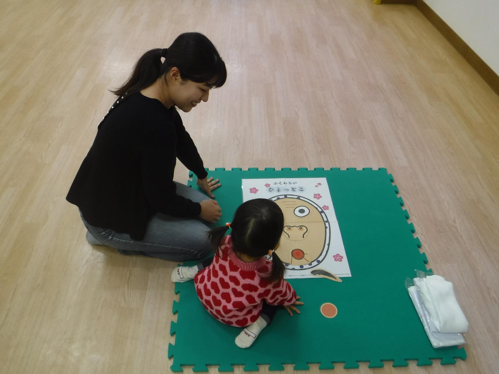 親子で福笑いをしている写真