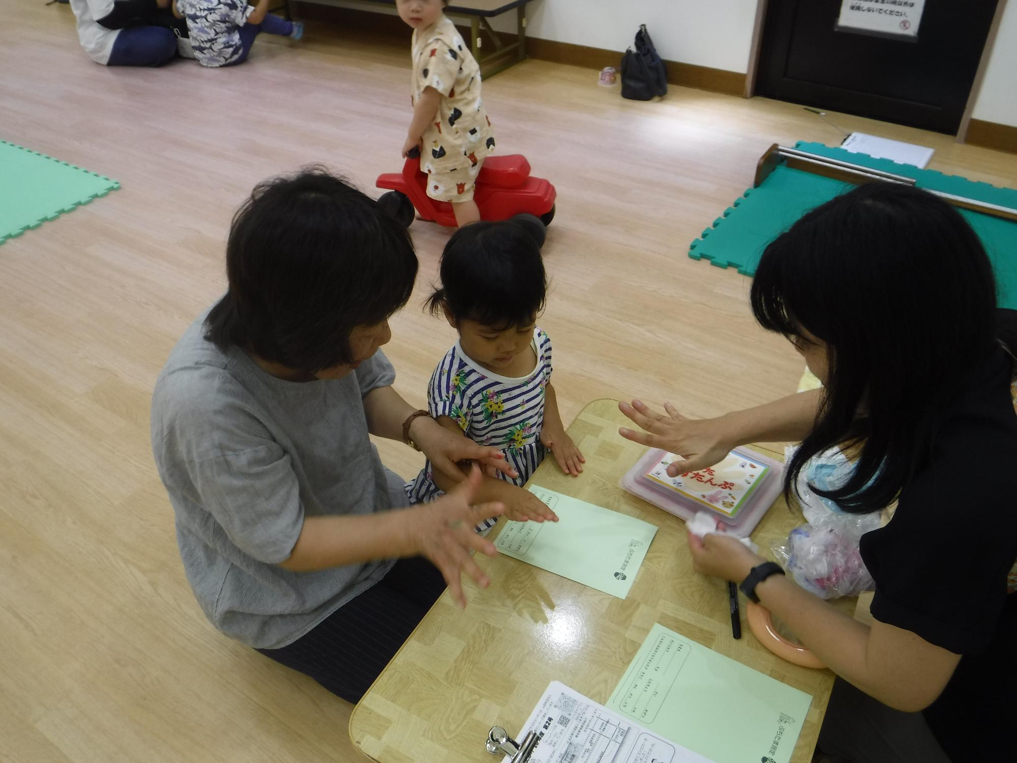 幼児が手形を取っている写真