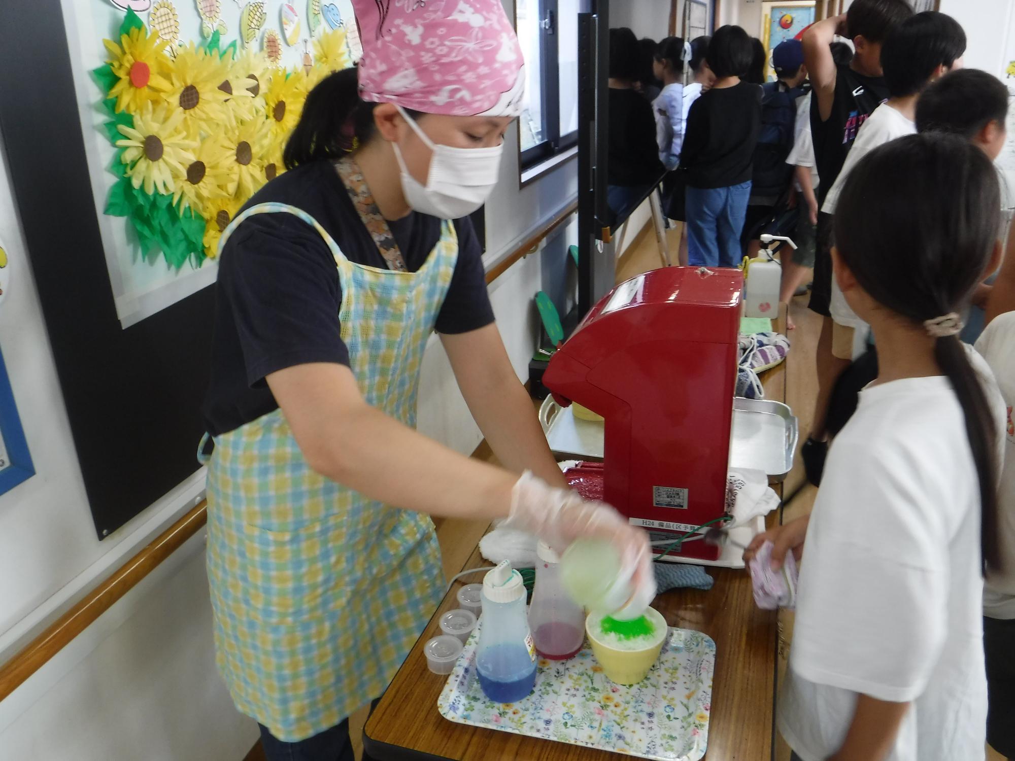 子どもがかき氷ができるのを待っている写真