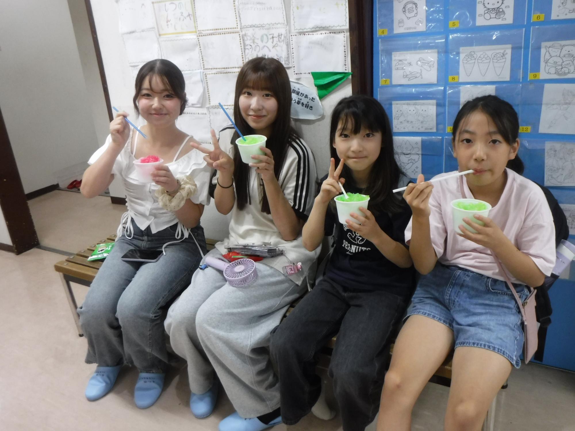大学生と楽しそうにかき氷を食べる子どもの様子