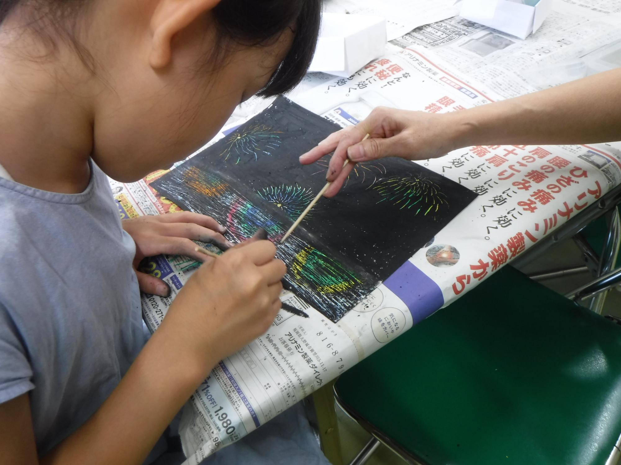 塗りつぶした箇所を削って色を出す作業をしている様子