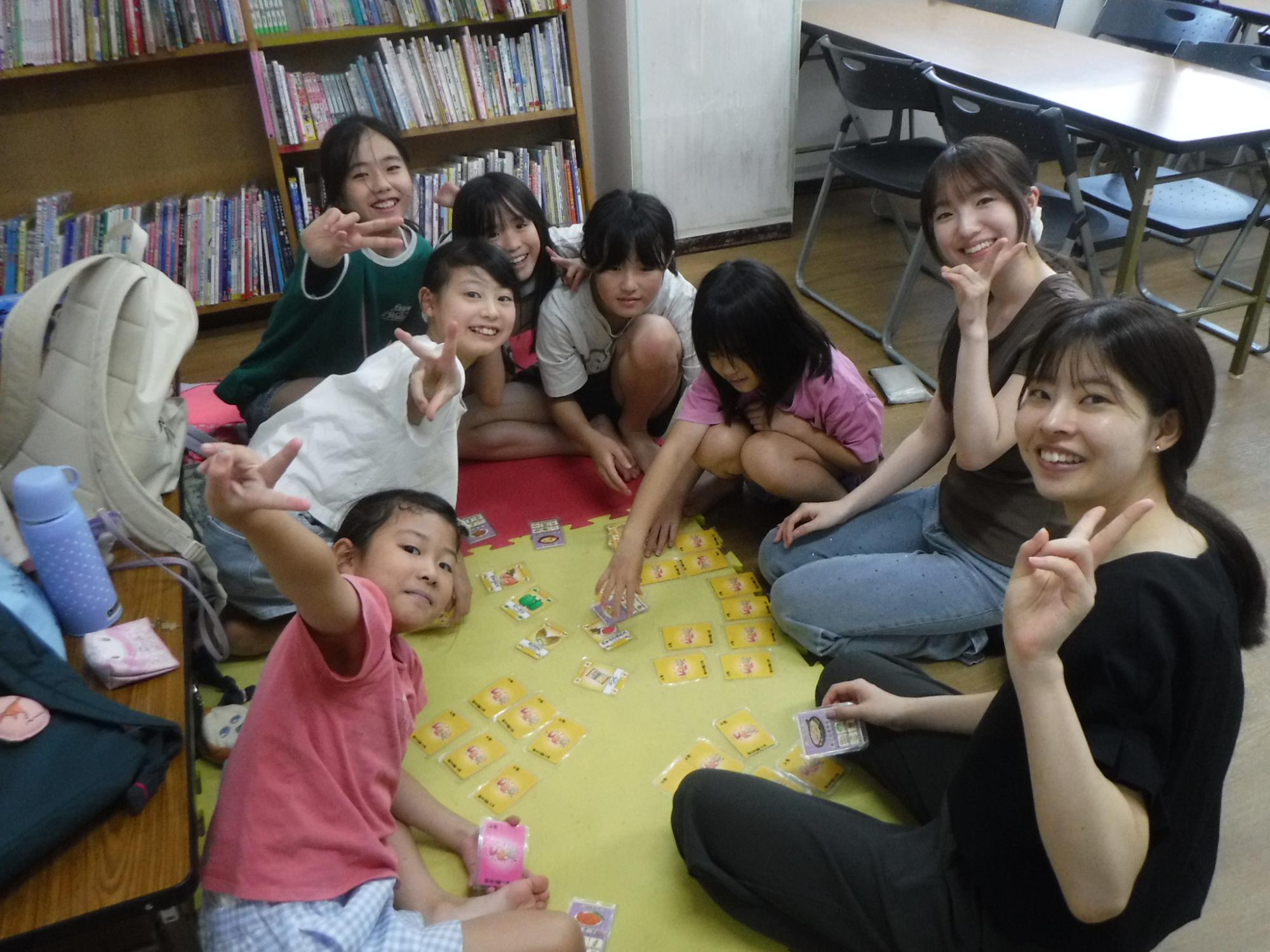 大学生は初めてのカードゲームを小学生に教えてもらい遊んでいる様子