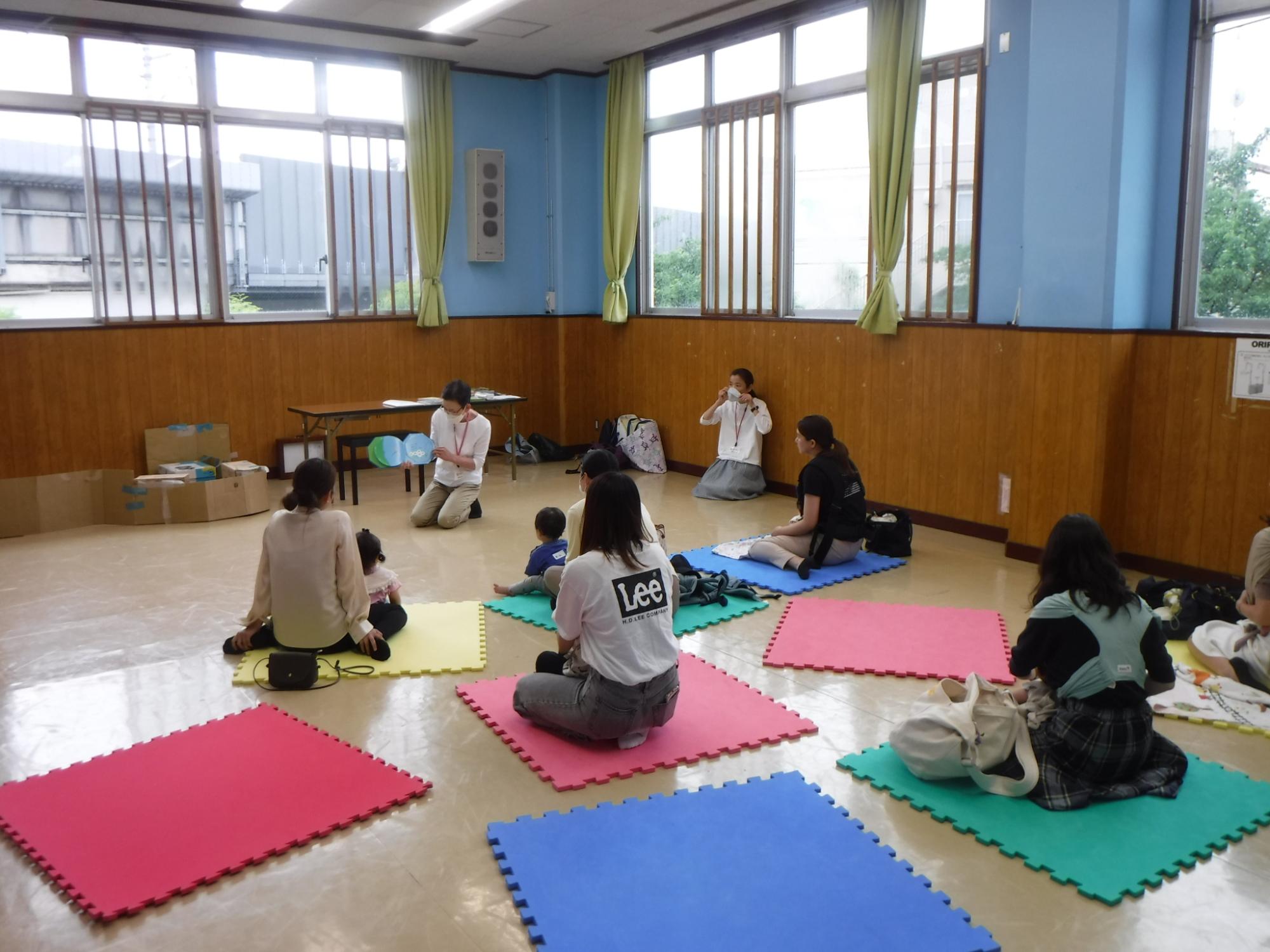 おはなしのぶらんこで読み聞かせに聞き入る親子