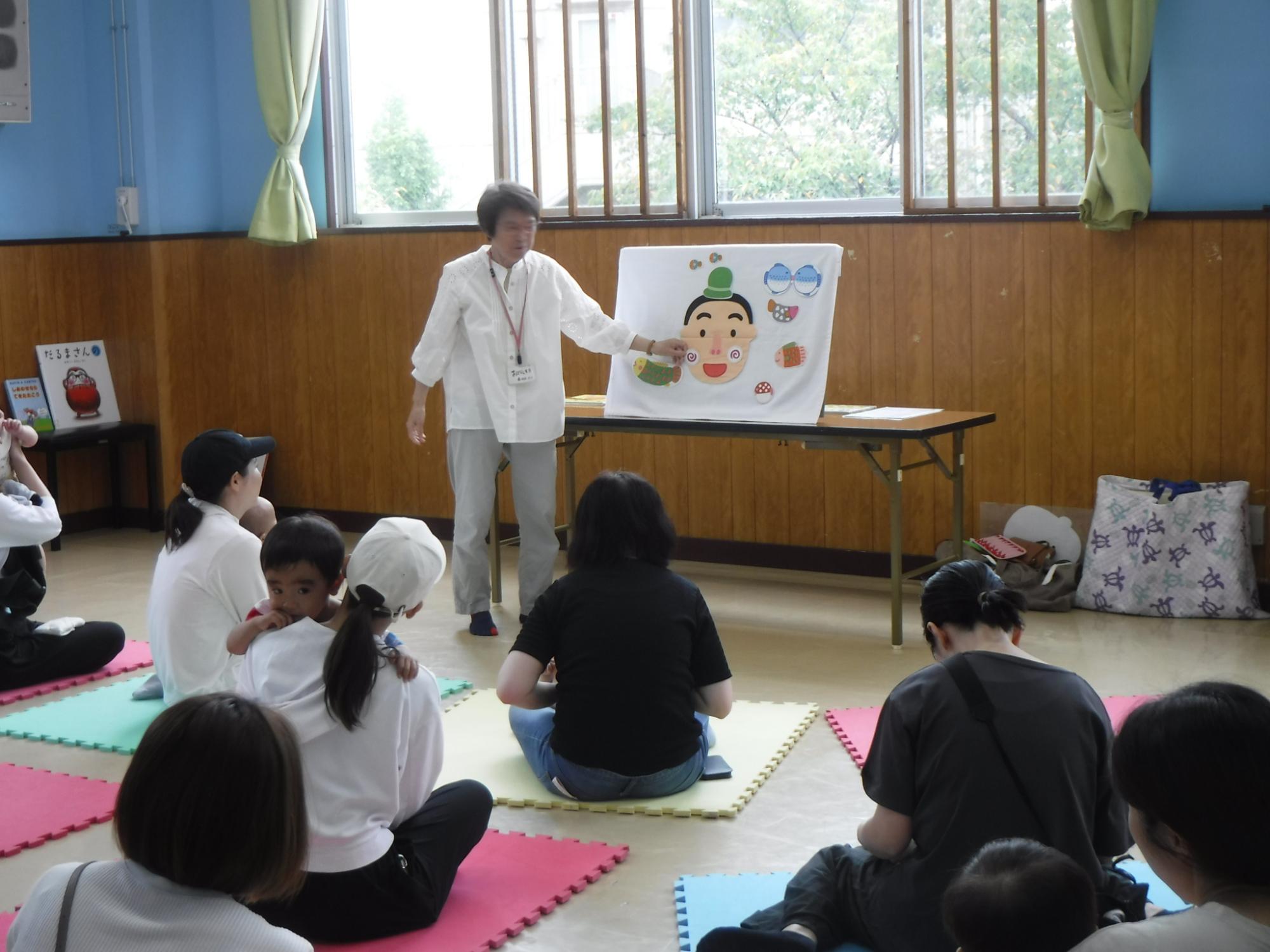 親子連れに向けて紙芝居を使って語り掛けている様子