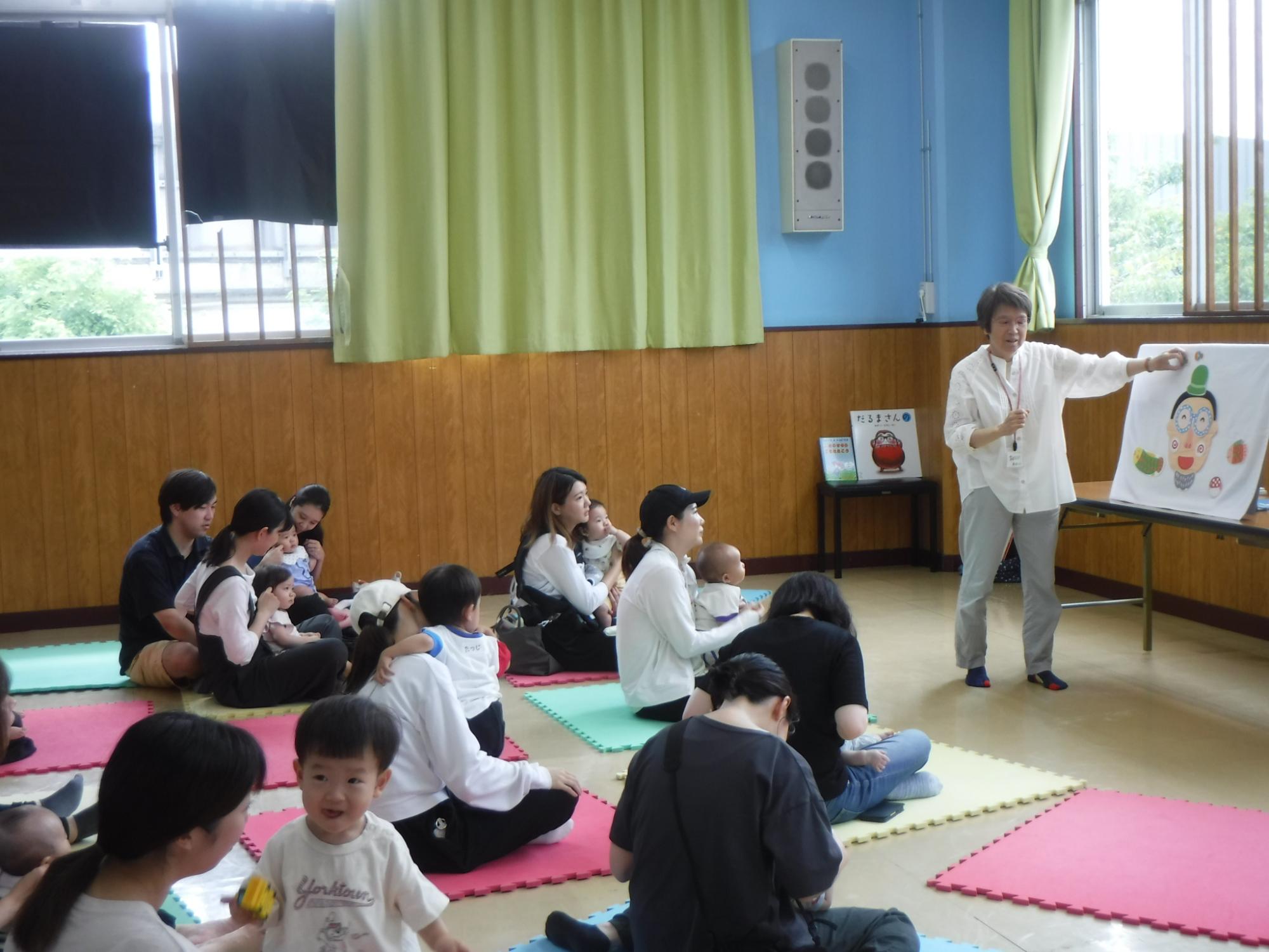 親子に向けて絵本の読み聞かせをしている様子