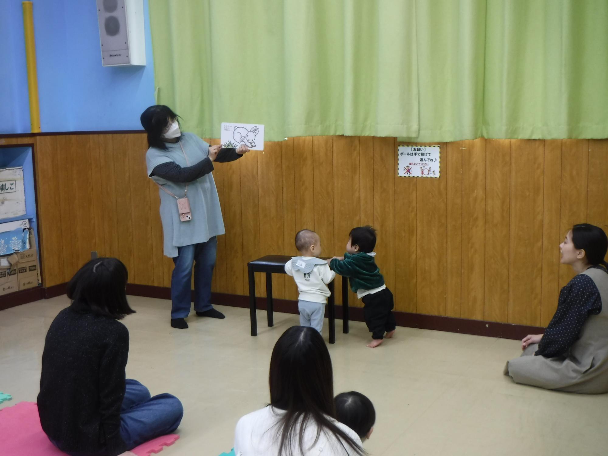 お友達と絵本に興味を持っている可愛い子どもの様子の写真