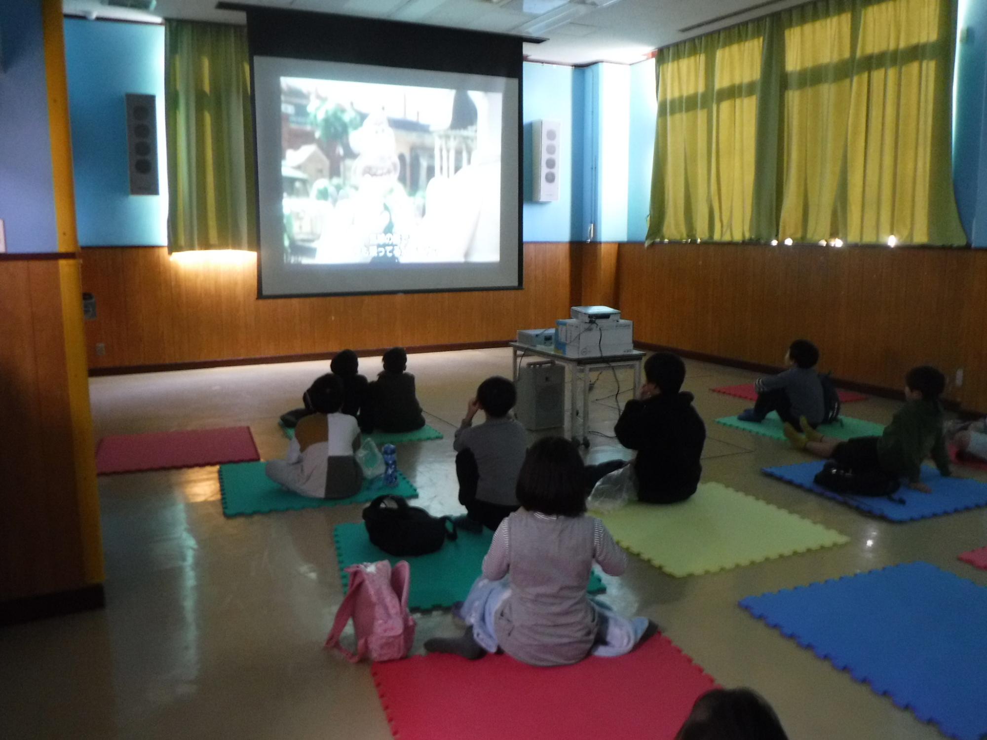 映画に見入っている子どもの写真
