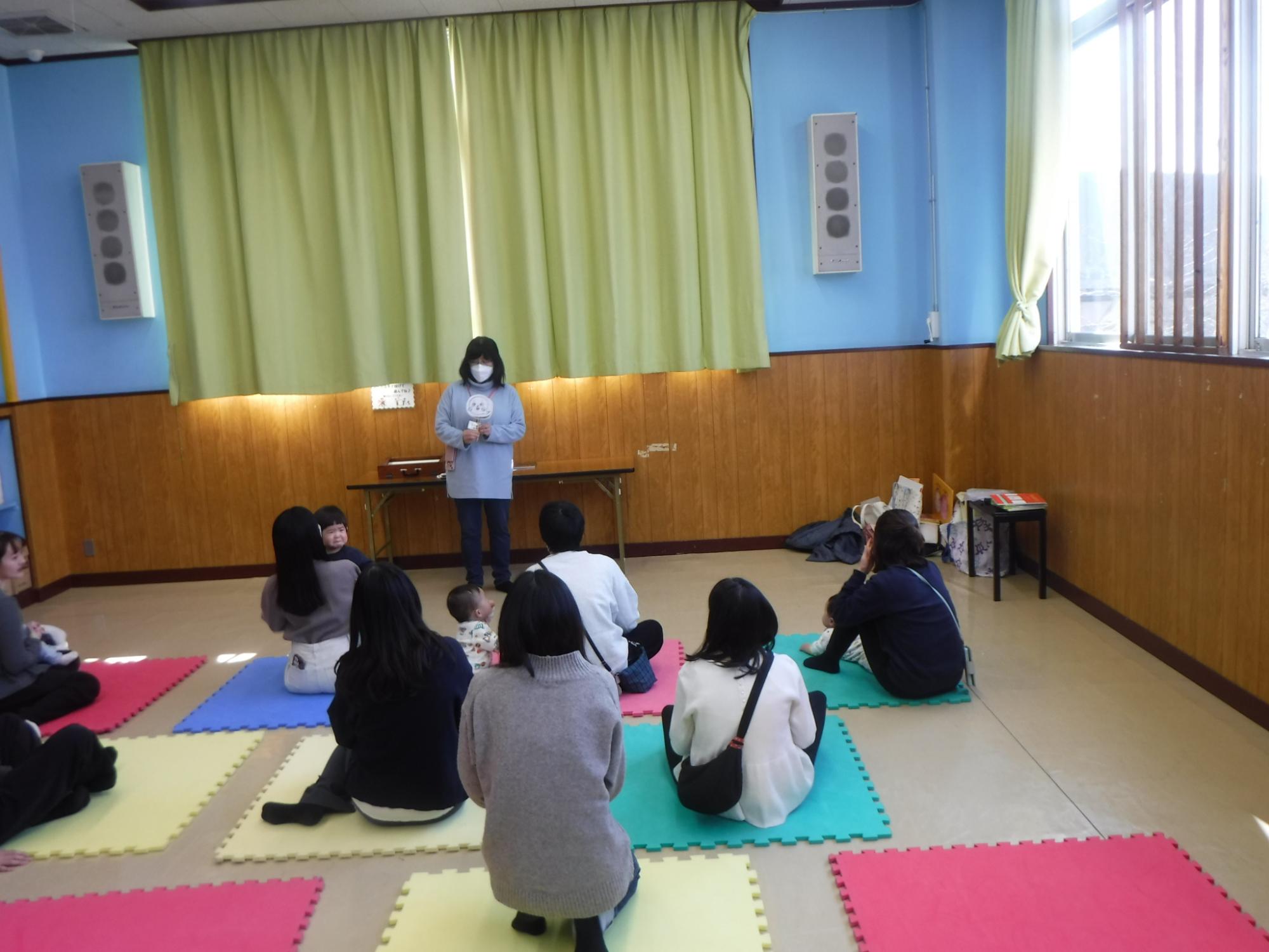 おはなしのぶらんこで読み聞かせに聞き入る親子