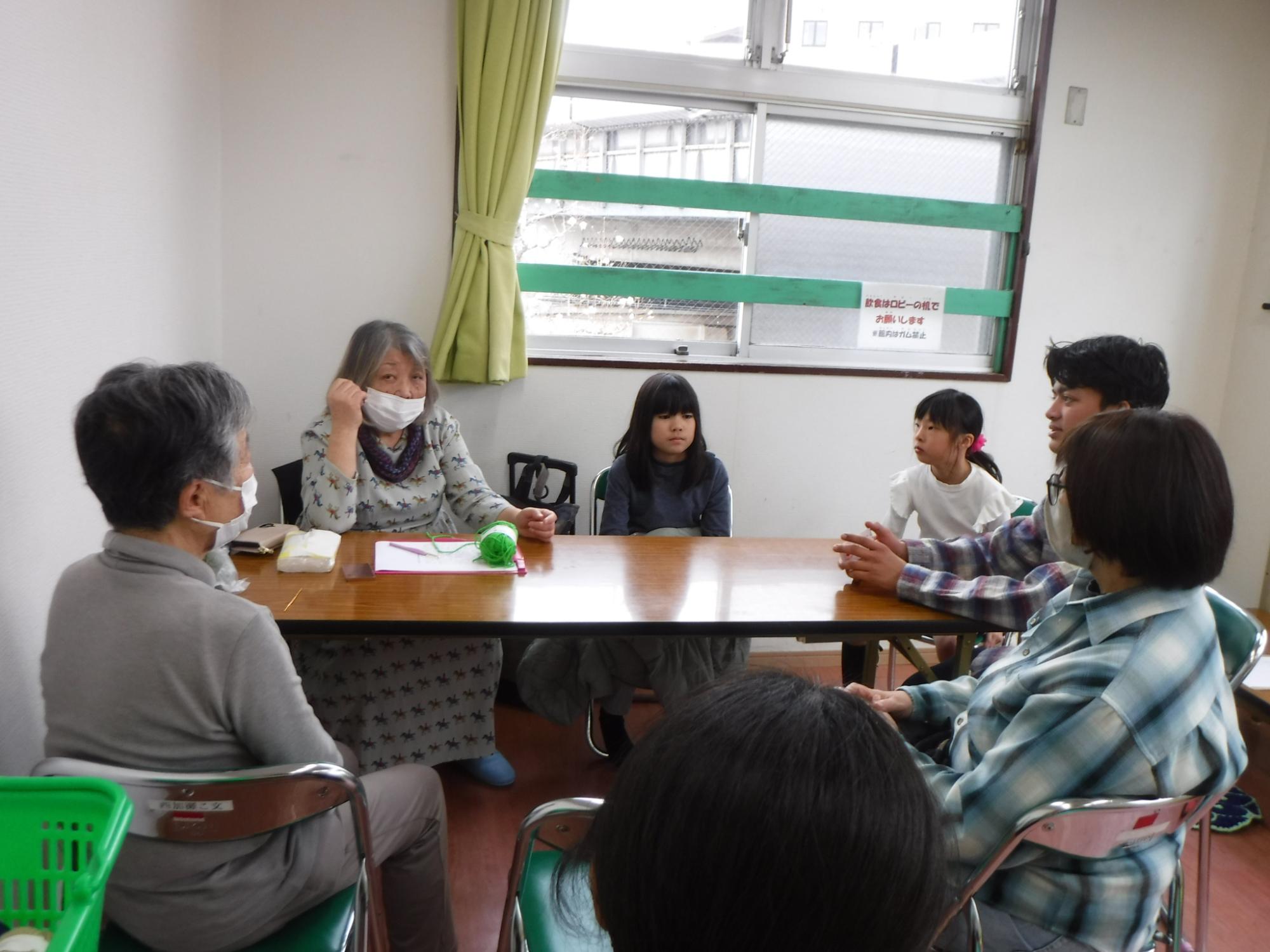 ヤーンボミングについて先生からのお話を聞いている写真