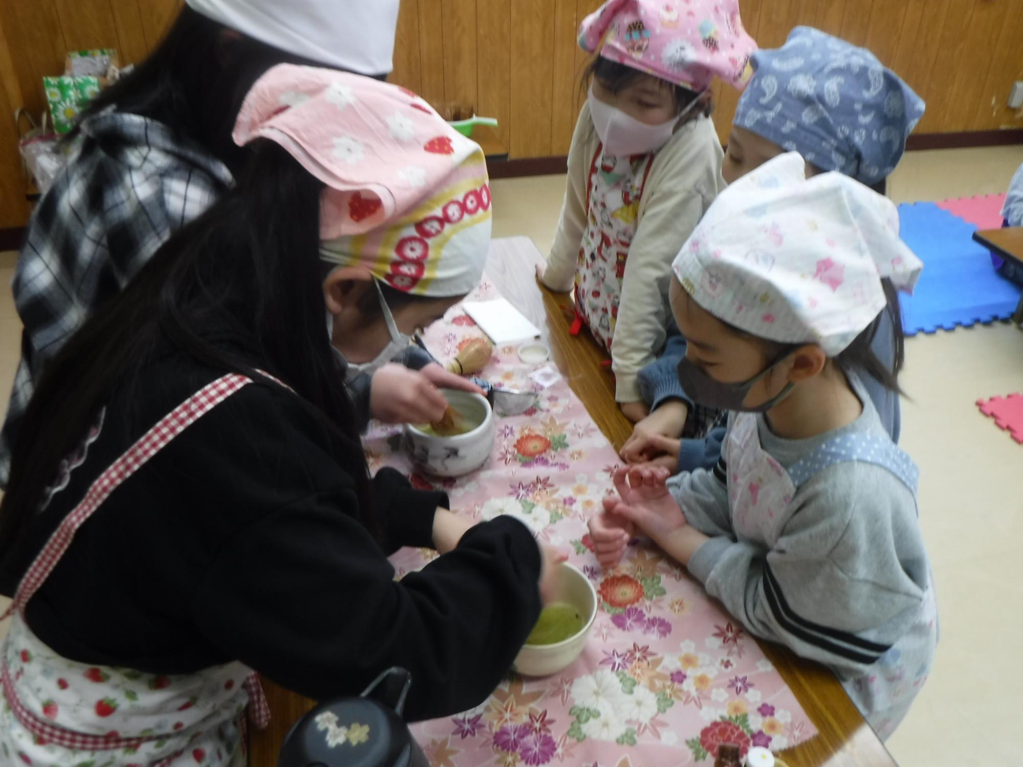 お茶の子クラブの子どもがお茶のたて方のお手本を見せている様子