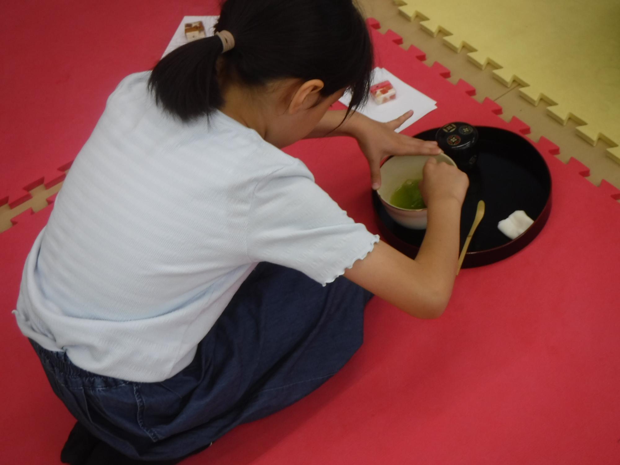 お茶を立てる子どもの写真