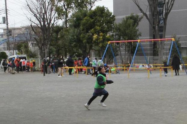 風車をもって公園を走る子ども