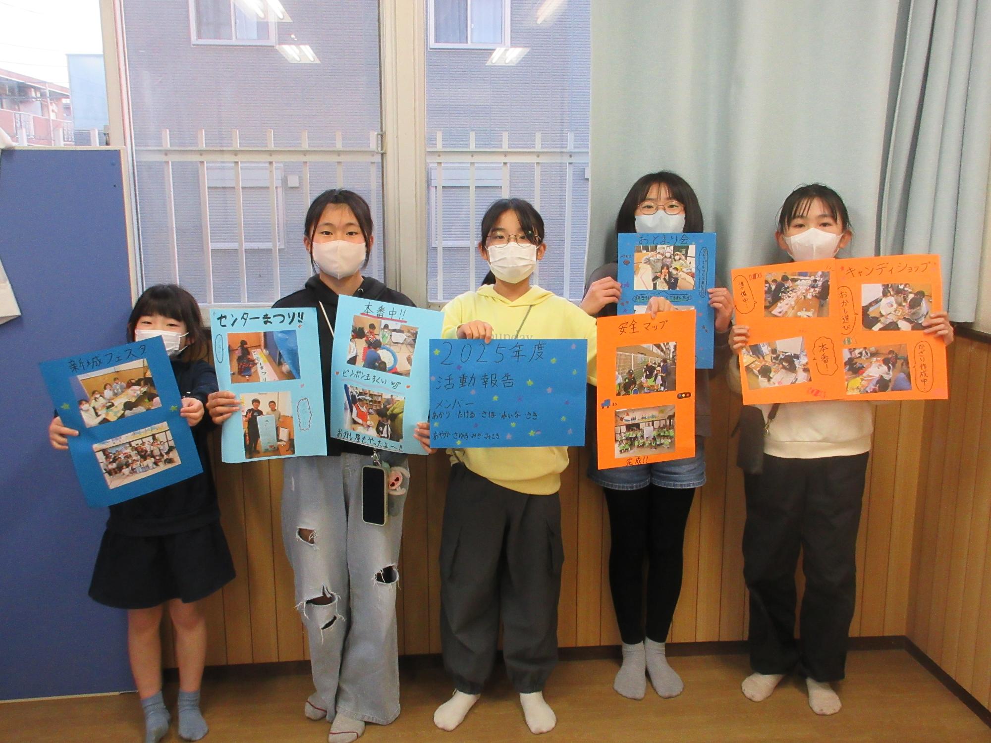 活動報告のポスターを持って並ぶ運営委員の子どもたち