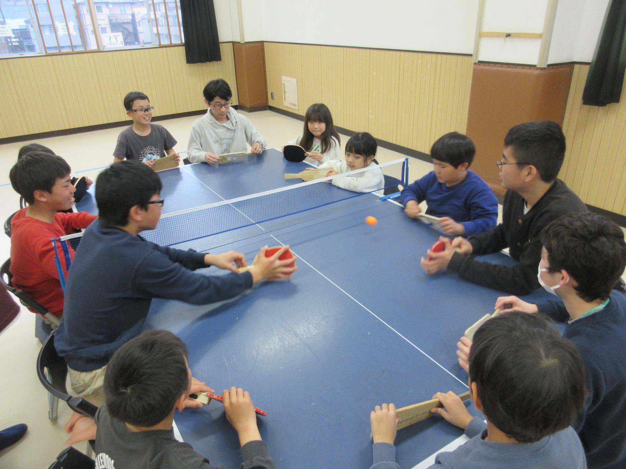 卓球台を囲む子ども達
