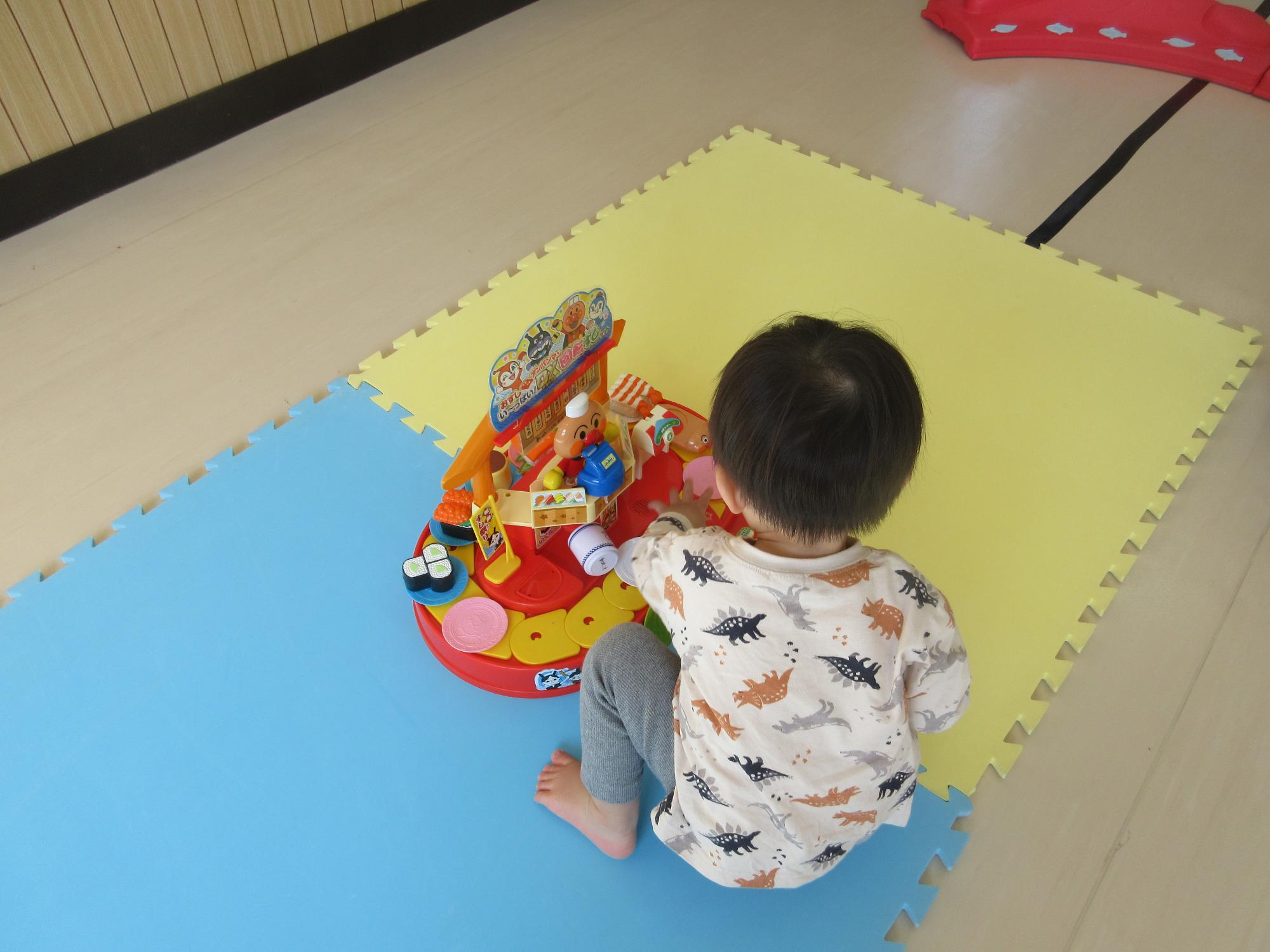 アンパンマンのお寿司屋さんで遊ぶ乳児