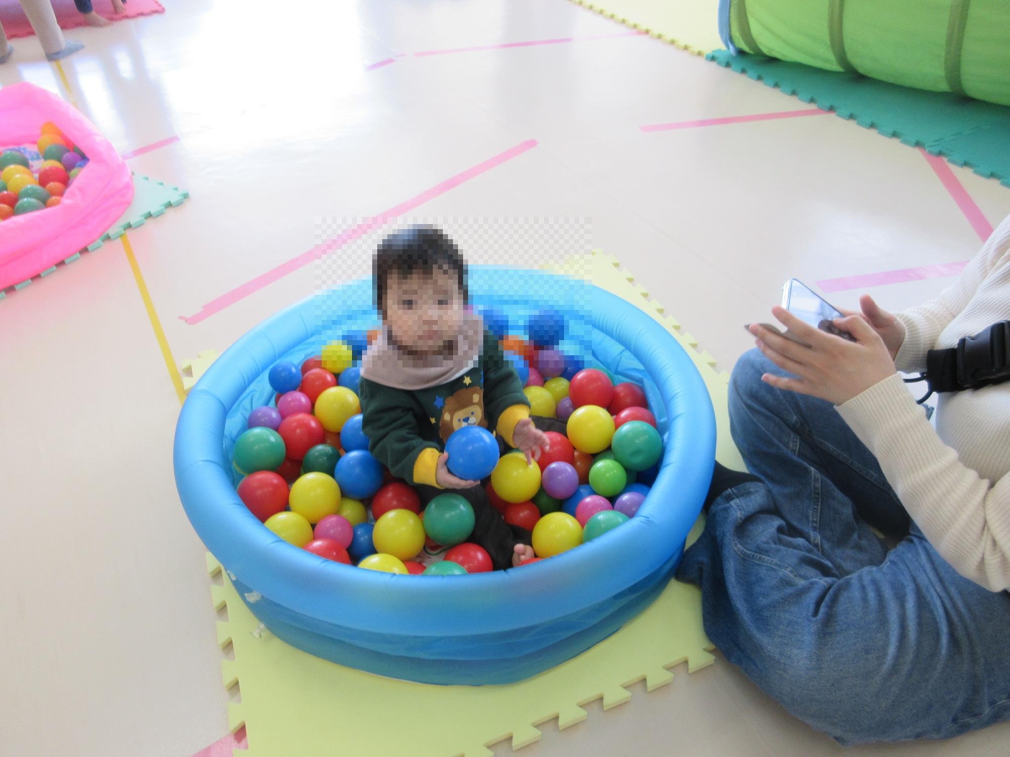 ボールがたくさん入ったプールに浸る乳幼児