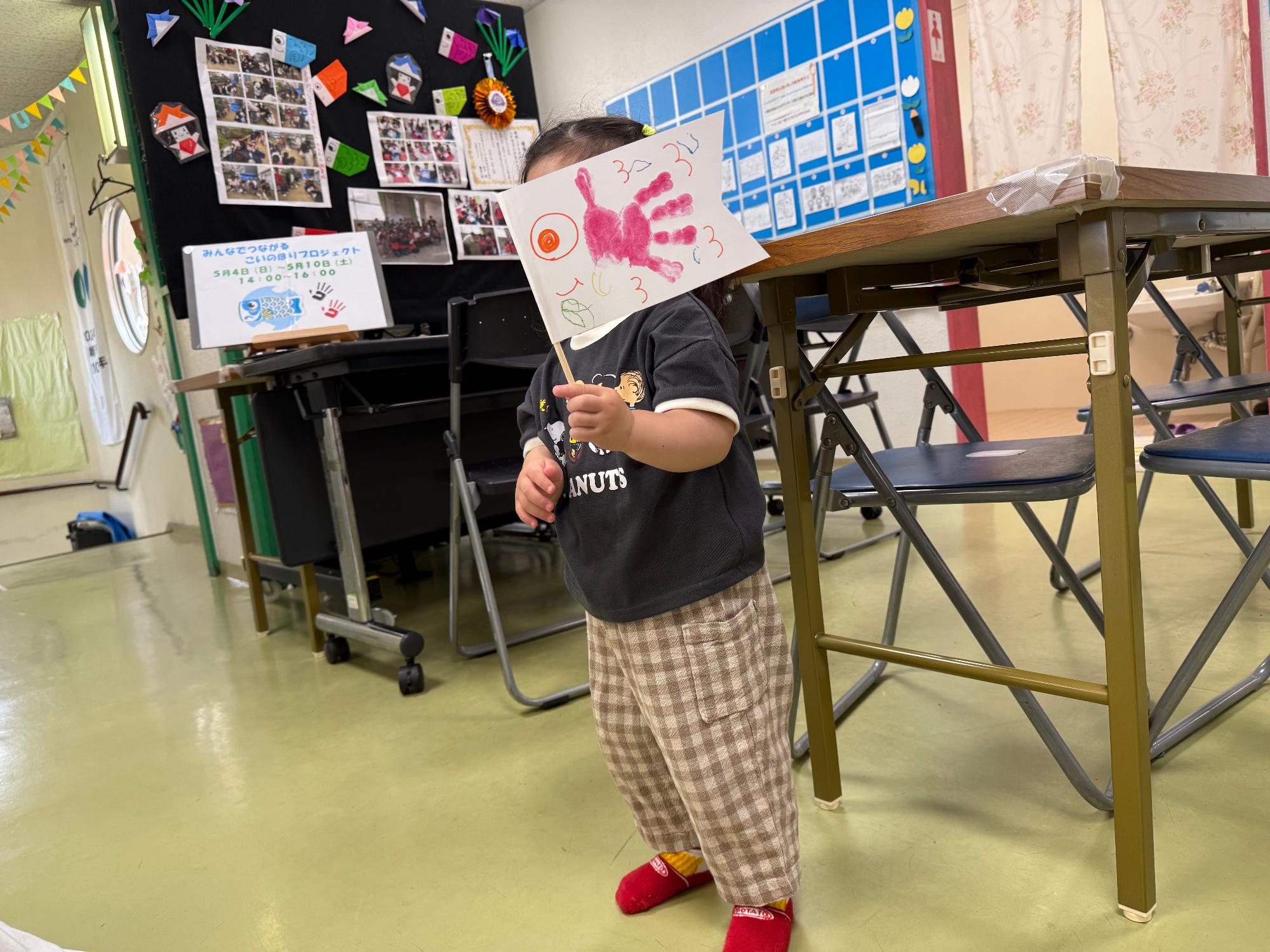 幼児さんがお土産用の手作りこいのぼりを持っている写真