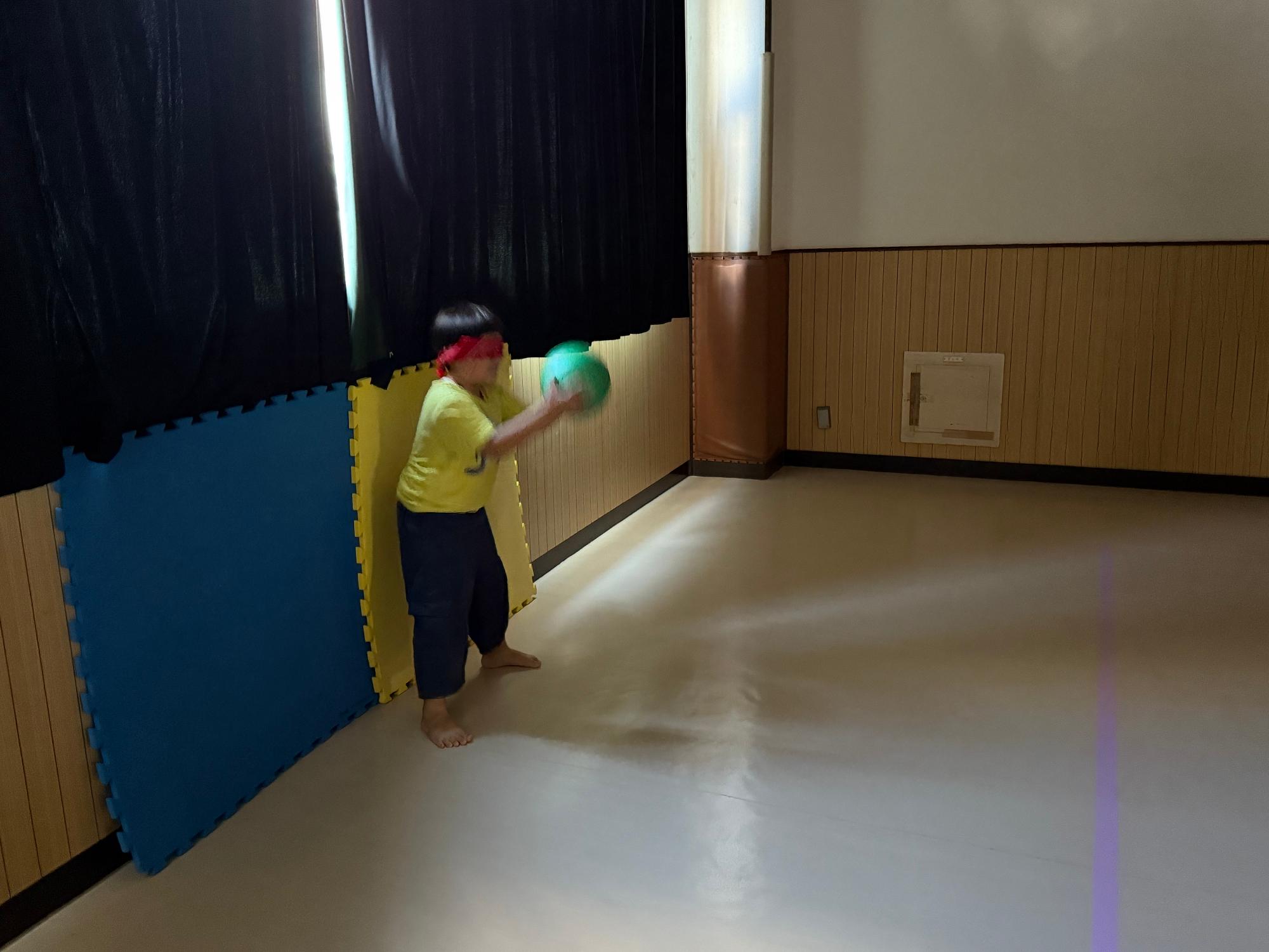 目隠しをした子どもがボールを手でキャッチしている写真