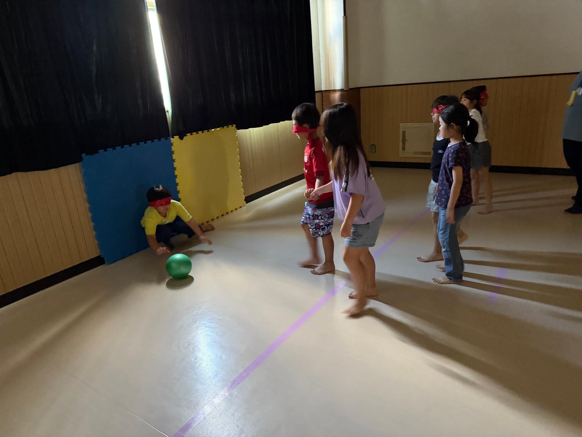 目隠しをした子どもがゴールに向かってボールを蹴っている写真