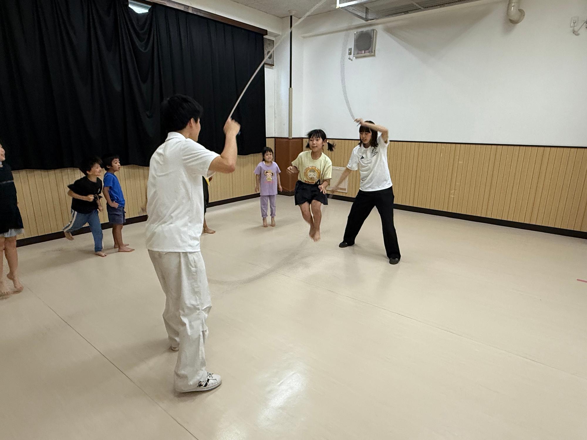 ダブルダッチの中に小学生が入って跳んでいる様子の写真