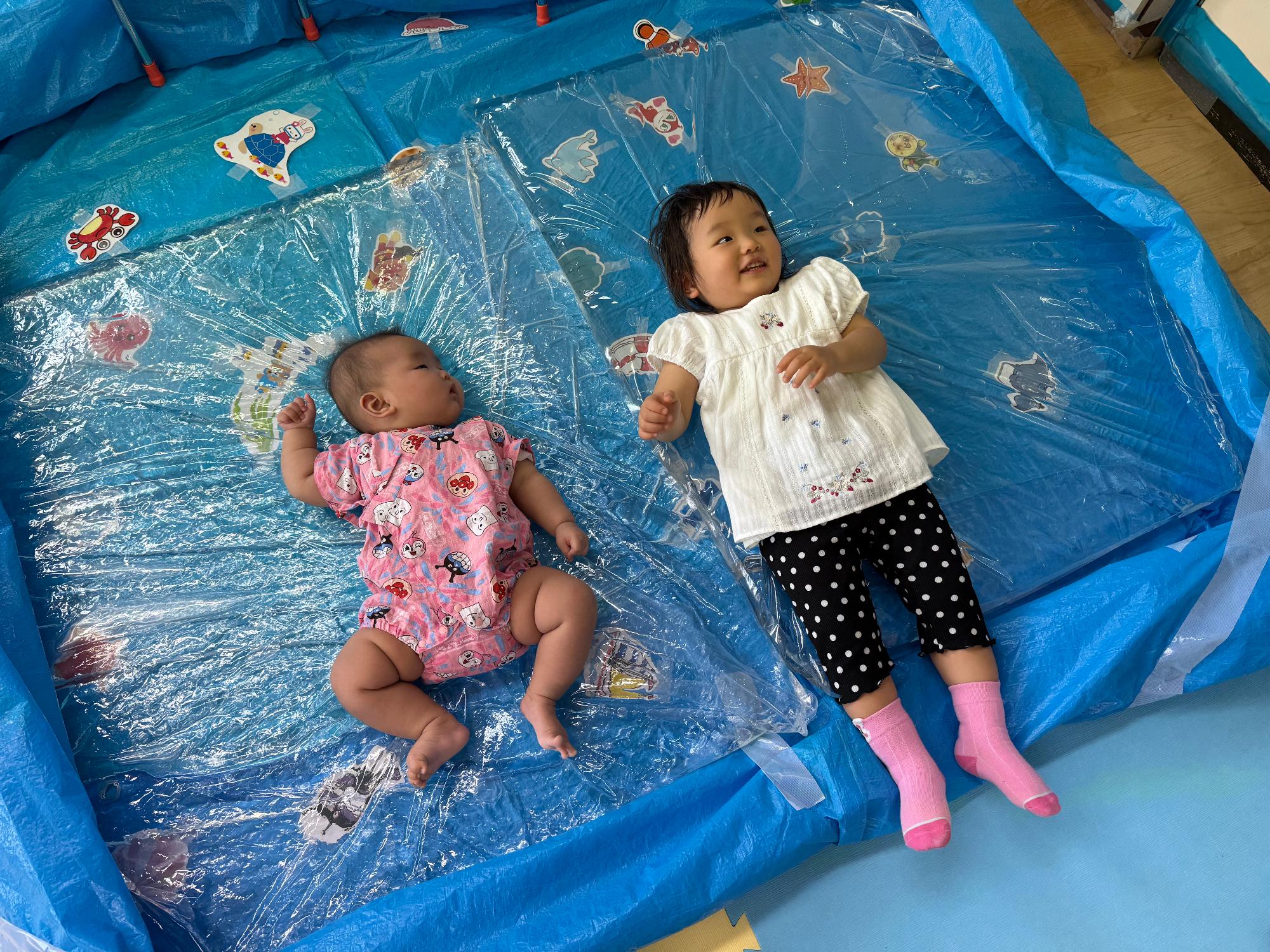 ウォーターベッドにあおむけで寝ている乳幼児の写真