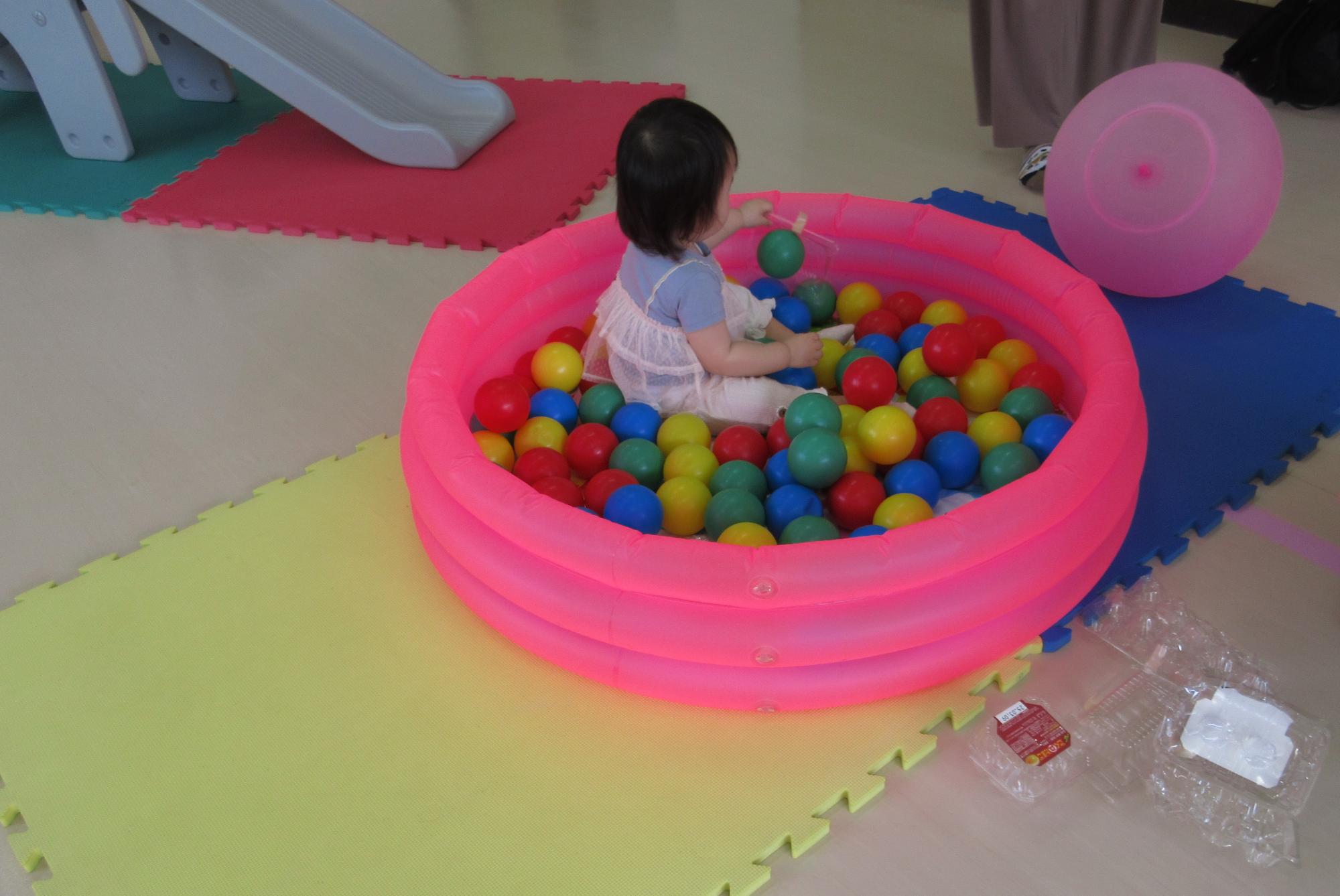 こどもがボールプールに入っている写真。