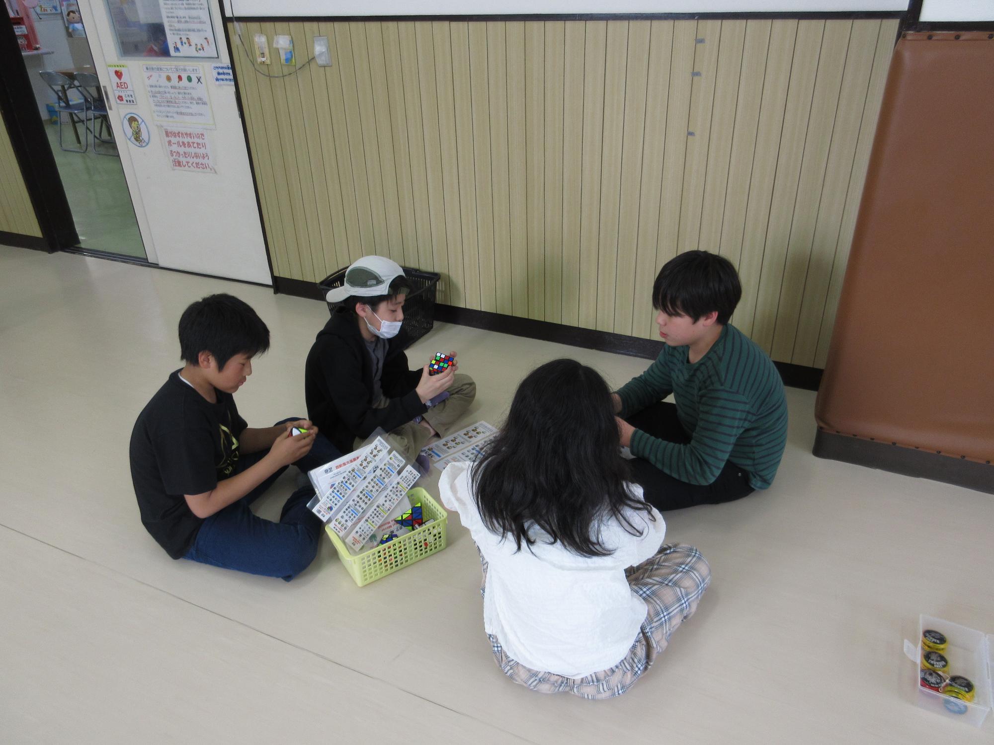 子どもがルービックキューブに取り組んでいる写真。